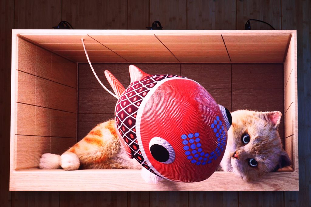 A kitten is playing with a ball in a box