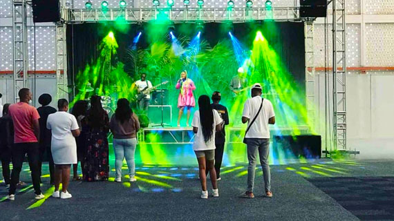The singer is singing on a stage set up by an outdoor rental LED display