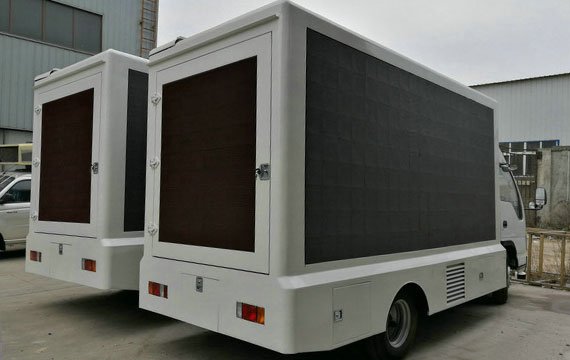 A mobile LED display parked outside the factory
